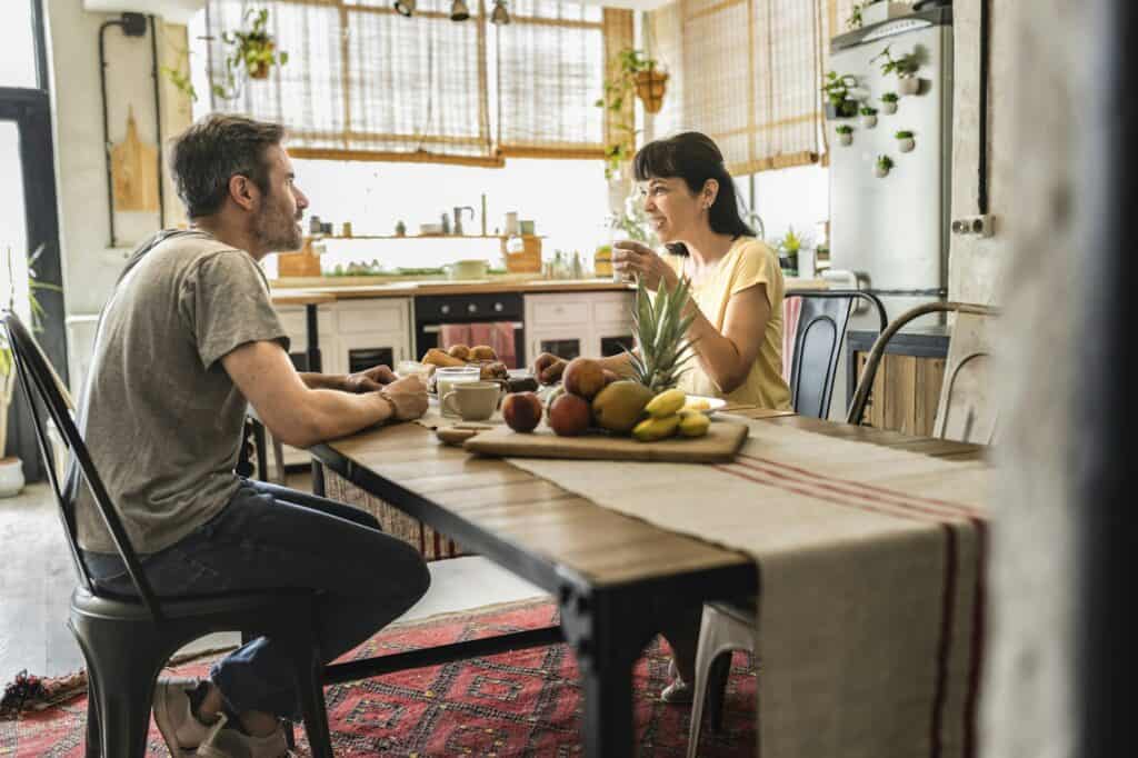 nice mature couple having breakfast together at dining table, happy